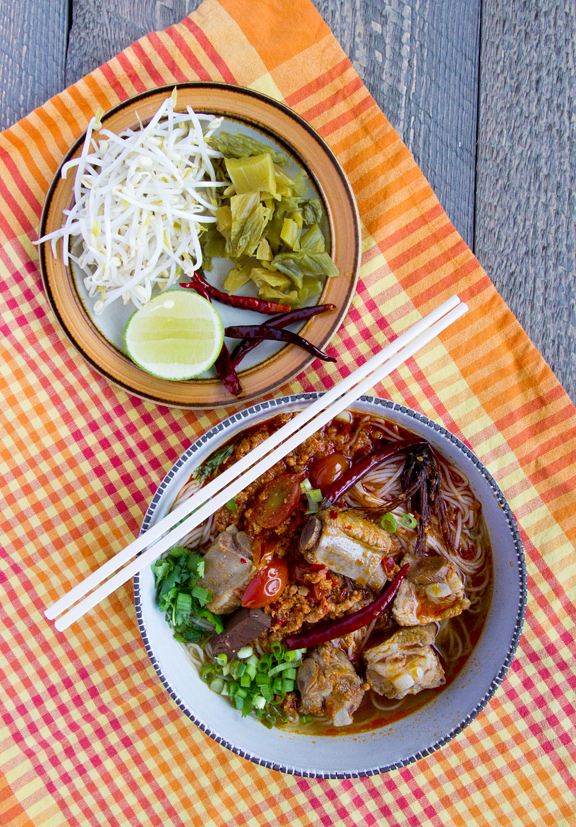 northern thai rice noodle soup with pork ribs dried cotton flowers and tomatoes - khanom jin nam ngiao